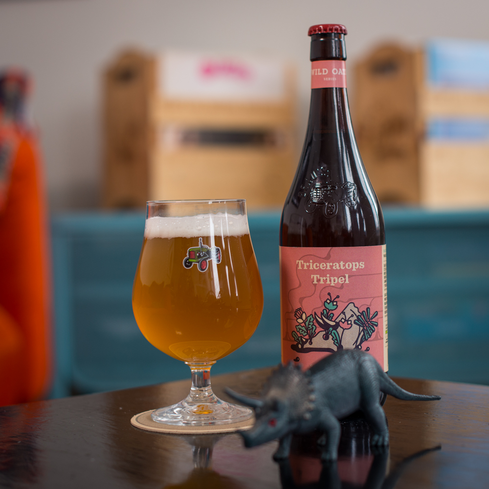 Glass of Triceratops Tripel with bottle